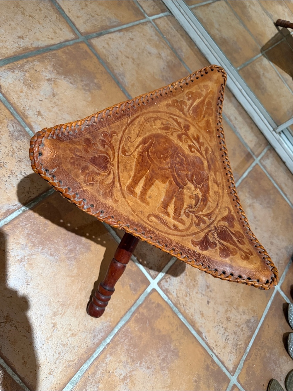 Hand crafted leather accent table with elephant design.